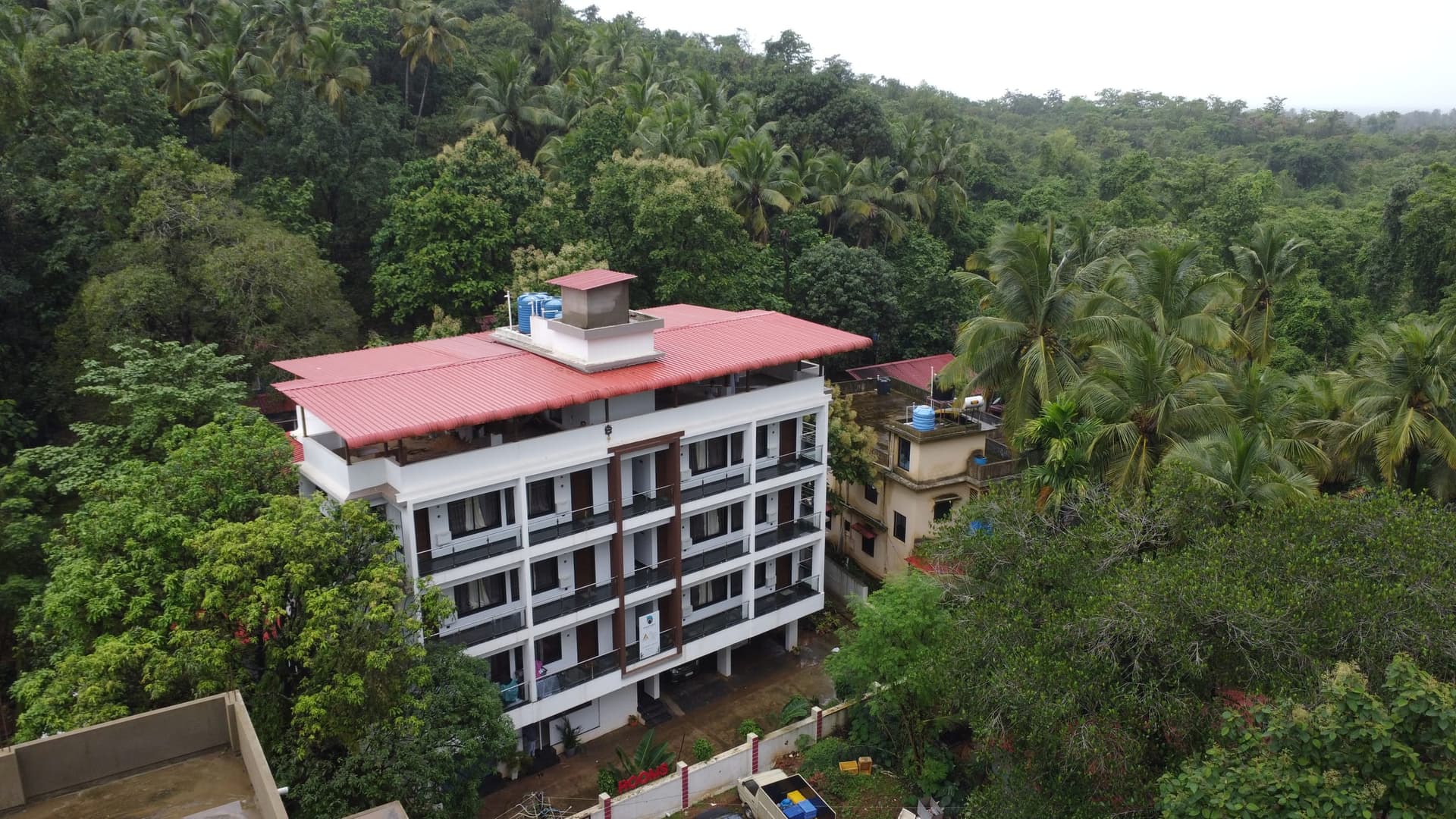 The house from the air at an angle, palms crowding the garden