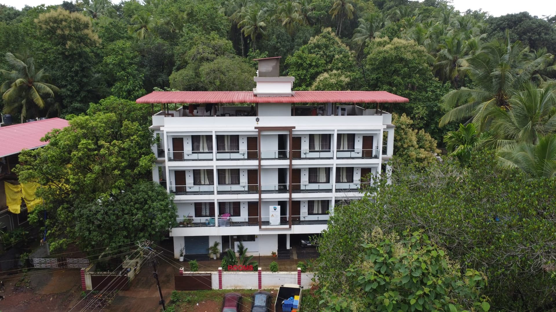 The house at balcony height from the drone, red roof and rooftop terrace