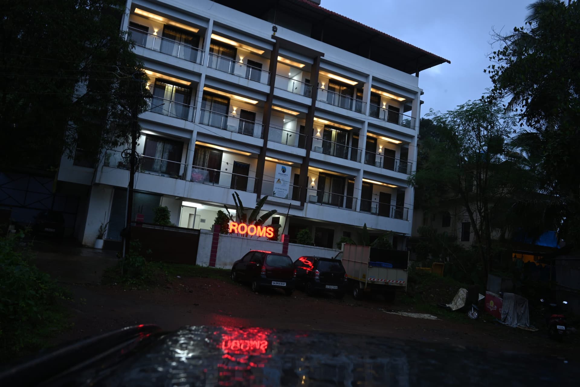 The lit house reflected in rainwater on the road