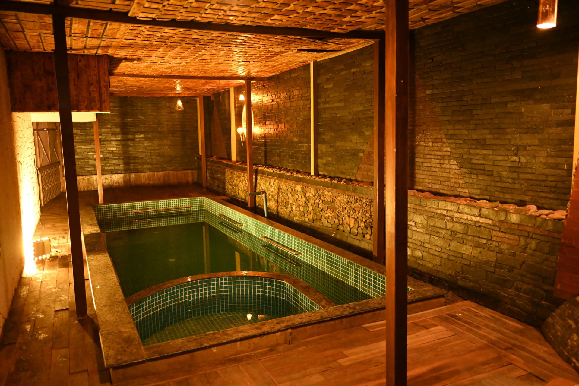 The pool from the far corner, stone walls and pebble border