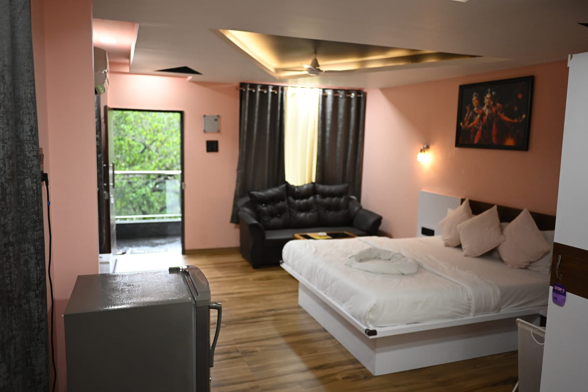 A suite with the balcony door open to the palms of Canacona